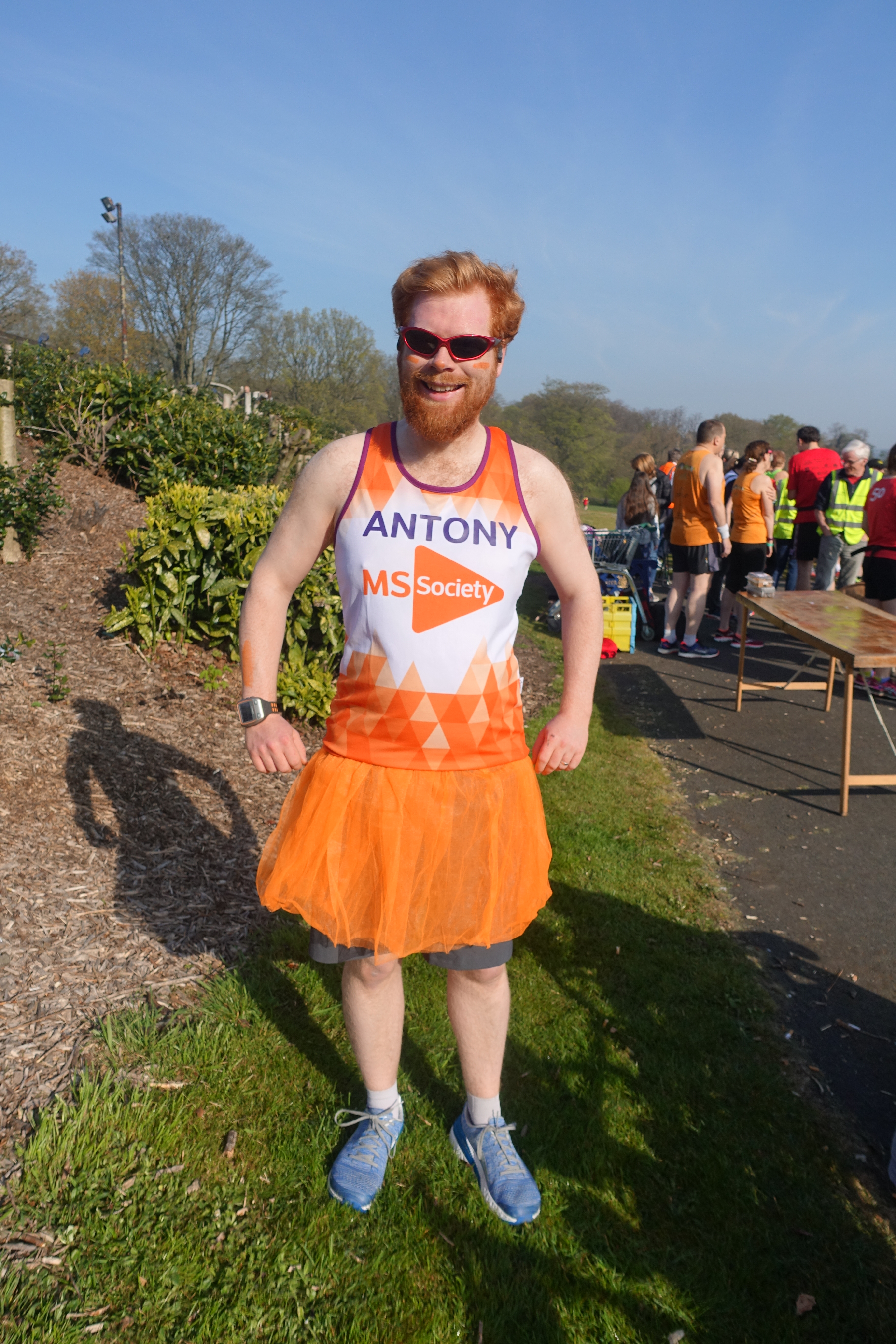 My ginger face with a bright orange t-shirt saying "Antony" in purple with the MS Society logo. I am wearing an orange tutu and blue running shoes.