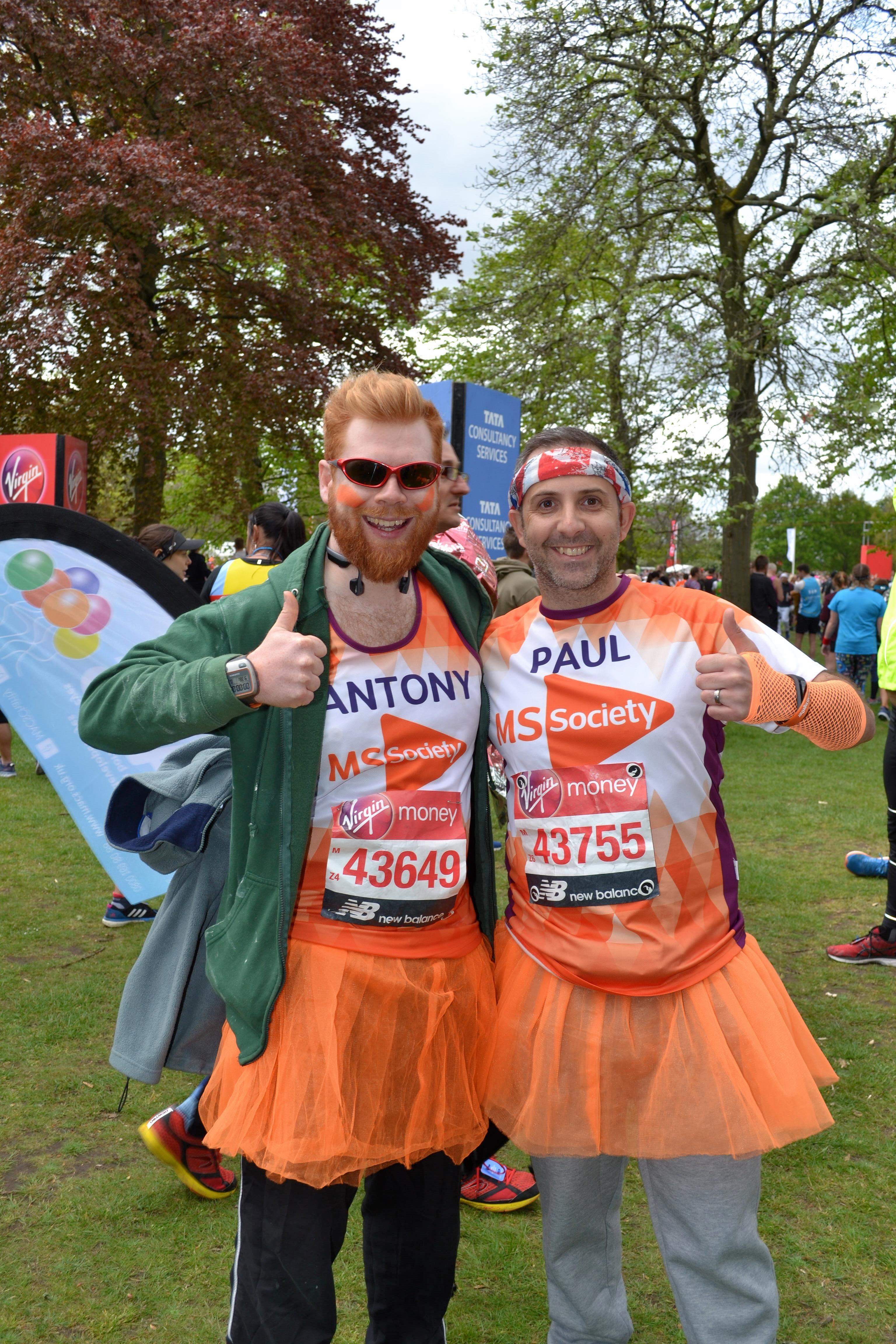 Two runners wearing orange MS Society t-shirts - one saying Antony, one saying Paul - with orange tutus on. We are both raising our thumbs and smiling